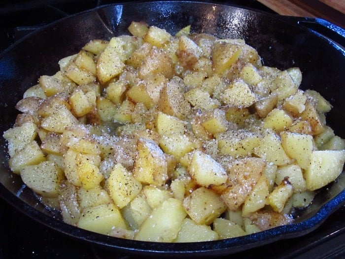 Seasoned potatoes in a cast iron skillet.