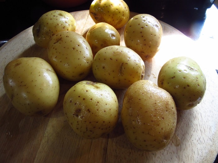 Golden potatoes on a cutting board.