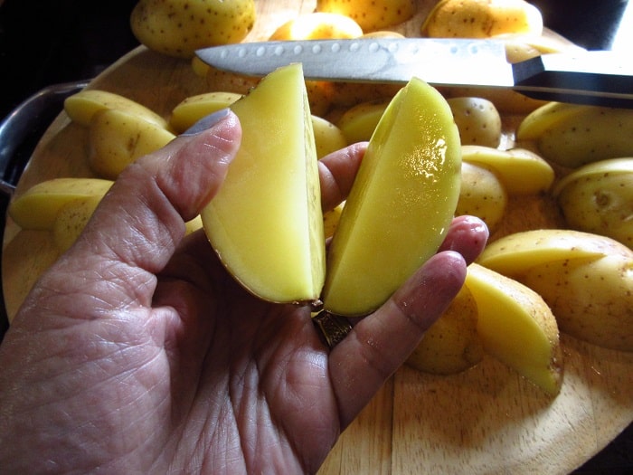 Sliced golden potatoes on a cutting board.