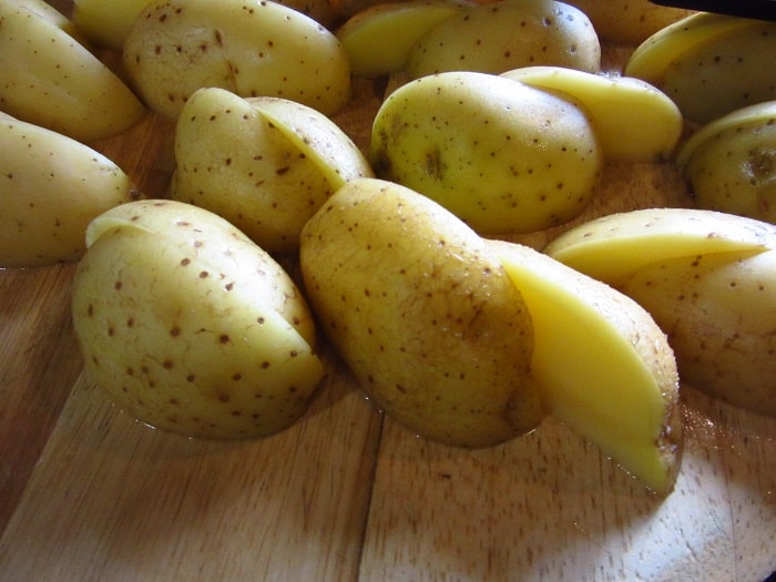 Cut golden potatoes on a cutting board.