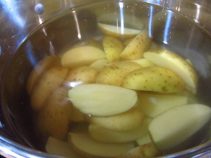 Potatoes in water in a stockpot.