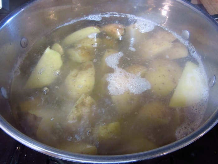 Potatoes coming to a boil in a stockpot.