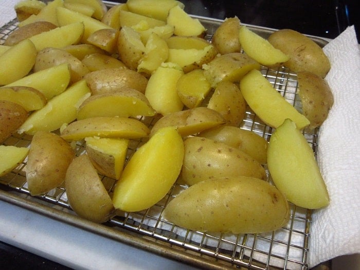 Golden cooked potatoes cooling on a rack.