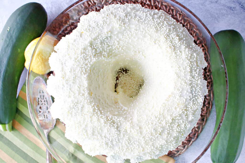 A direct overhead photo of a Gingerbread Bundt Cake with Zucchini frosted with Lemon Ginger Buttercream Frosting along with non-pareils