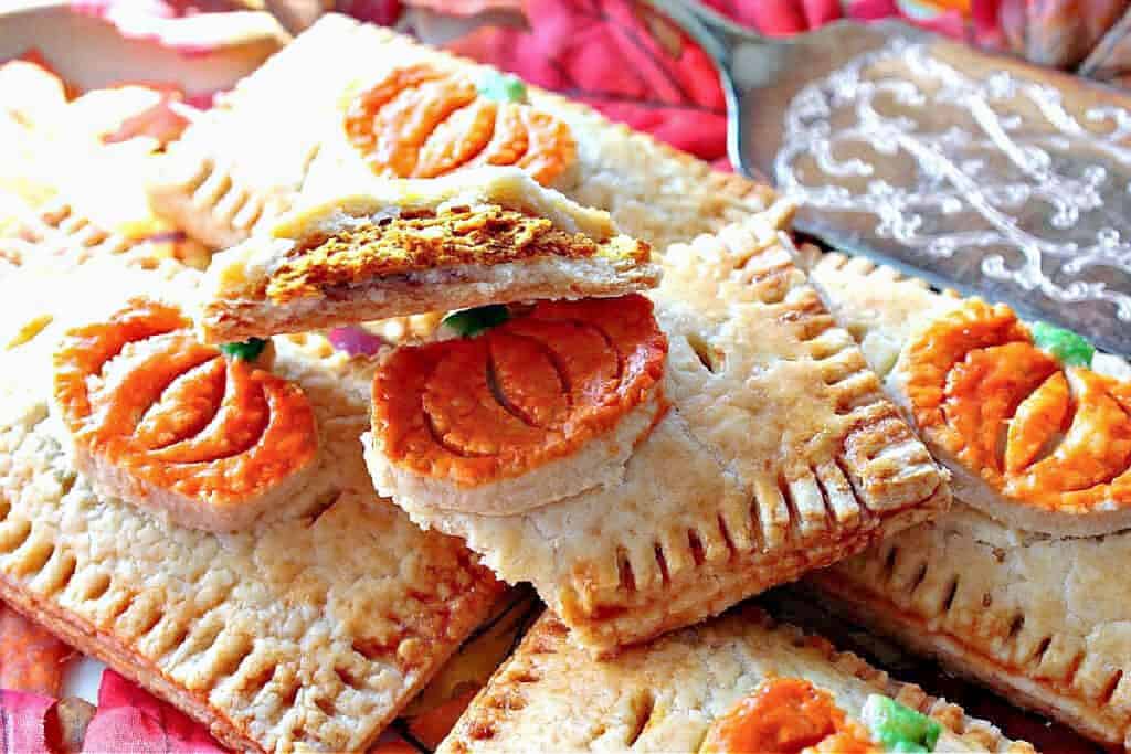 A closeup look at the inside of a Pumpkin Hand Pie with painted pumpkin embellishments and flaky pie crust.