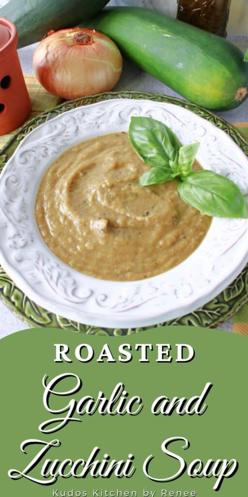 A vertical image along with a title text overlay graphic for Roasted Garlic and Zucchini Soup with fresh basil as garnish.