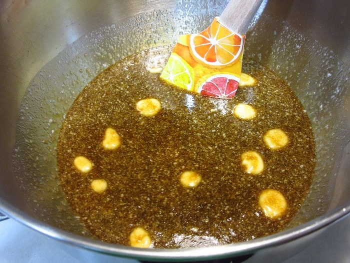 A spatula in a bowl with melted butter and molasses.