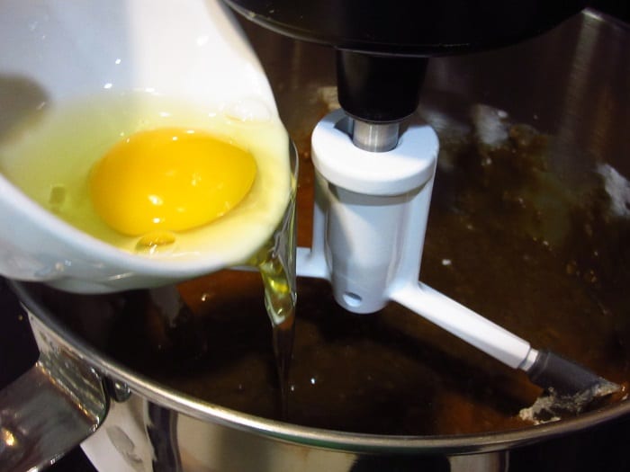 Egg being added to a stand mixer.