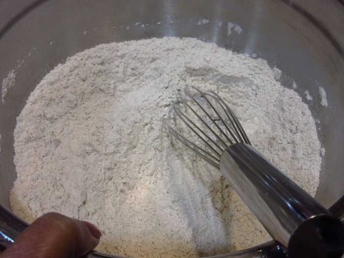 A whisk in a bowl of dry ingredients.