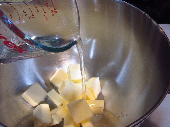 Water being added to a bowl of butter.