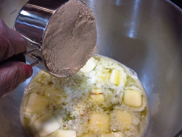 Brown sugar being added to a bowl.