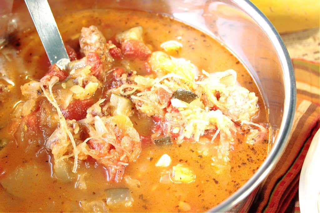 An offset horizontal photo of a pot of Spaghetti Squash Soup with a ladle.