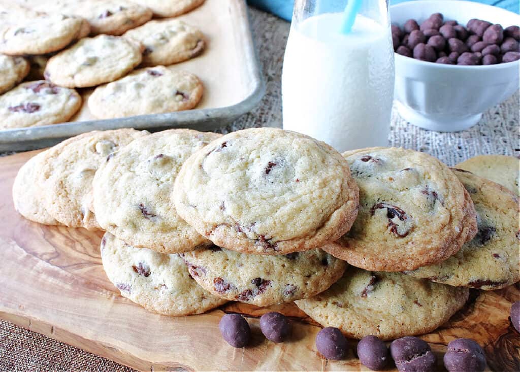 A horizontal photo of a baking sheet and wooden tray filled with Chocolate Chip Espresso Bean Cookies.