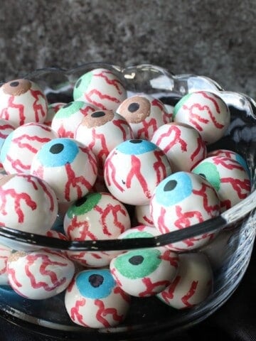 A glass bowl filled with colorful Gumball Eyeballs.