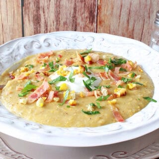 A pretty white bowl filled with Roasted Corn and Potato Chowder along with fresh parsley and bacon on top.