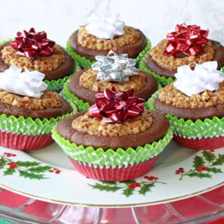 A festive plate filled with Gingerbread Pecan Pie Tarts with holiday bows on top.