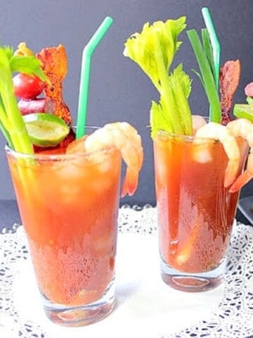 Two Bacon Bloody Mary's with celery, shrimp, and bacon.