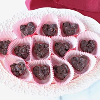 An overhead photo of a plate of Chocolate Covered Dried Cherries in red paper cups.