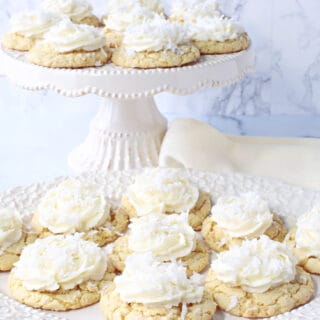 Two trays of Coconut Cake Cookies with white buttercream frosting topped with coconut.