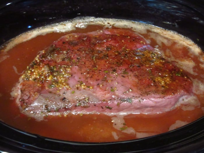 A cooked corned beef in a slow cooker.