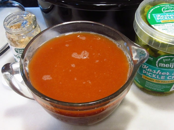 A glass bowl full of a red pickling spice liquid.