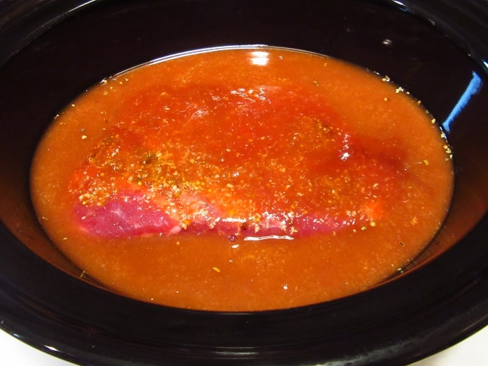 A pickling liquid and corned beef in a slow cooker.