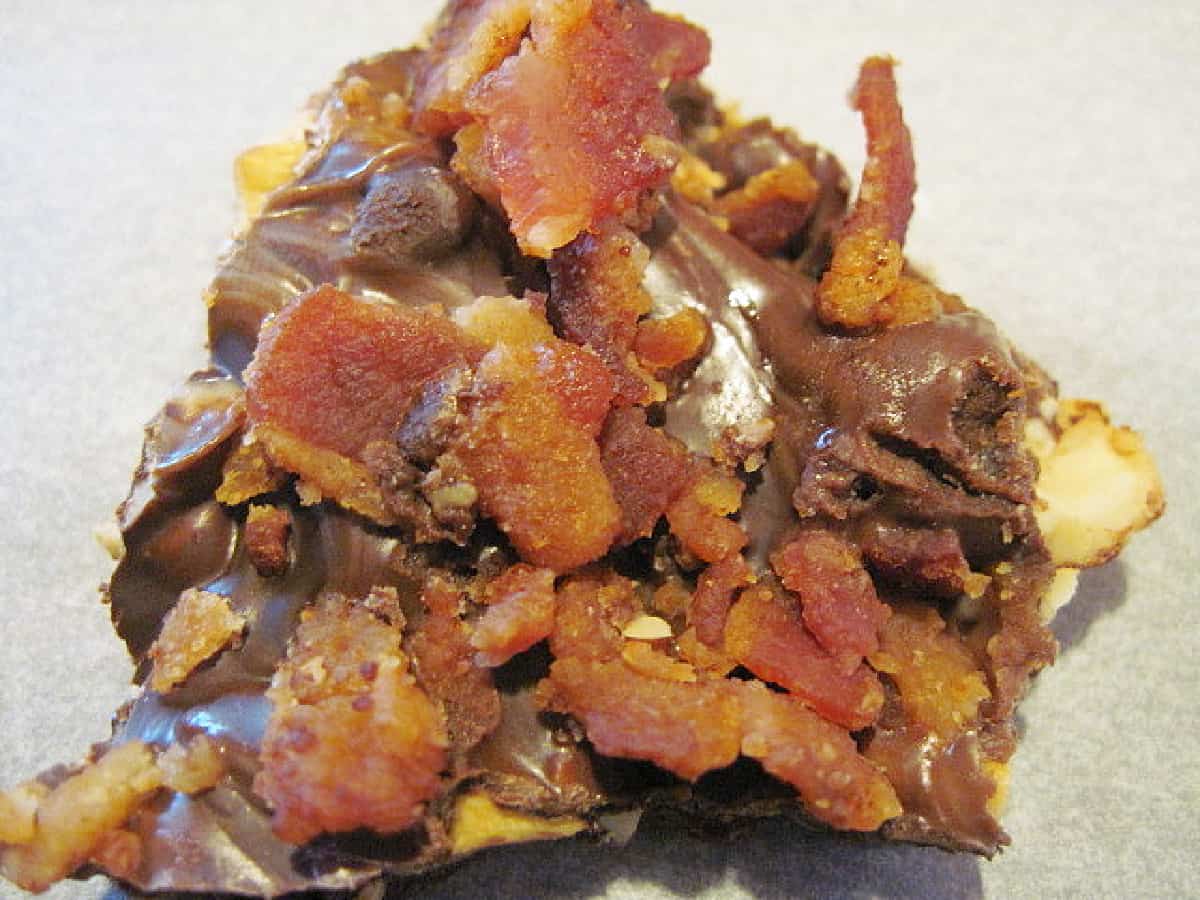 A super close photo of a piece of Bacon Cashew Bark with semi-sweet and white chocolate.