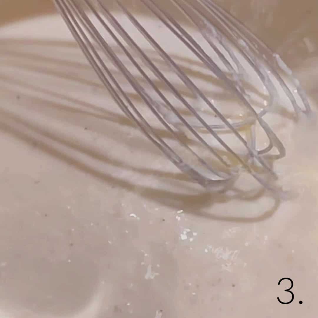 A whisk making Alfredo sauce.