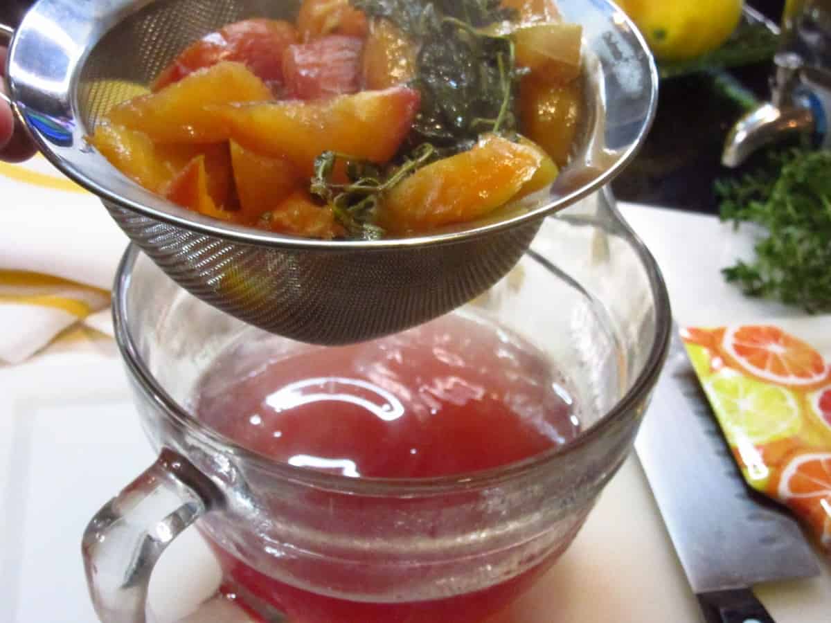Peaches and basil in a strainer making simple syrup.