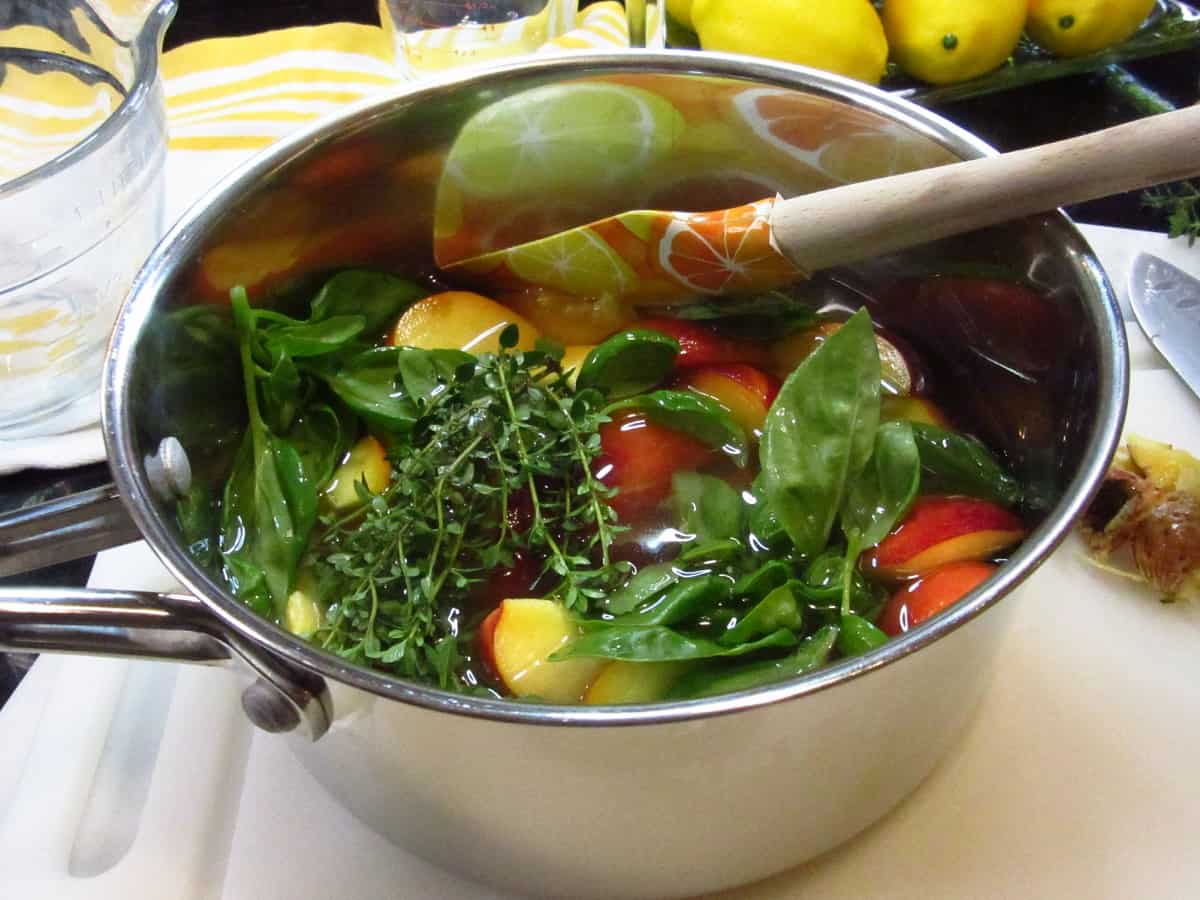 Peaches and herbs in a saucepan.