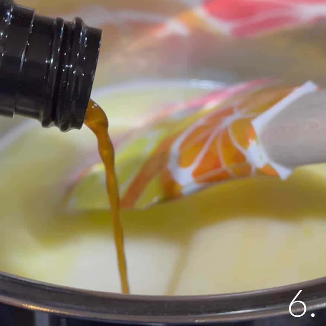 Vanilla extract being poured into cupcake batter for Boston Cream Cupcakes.