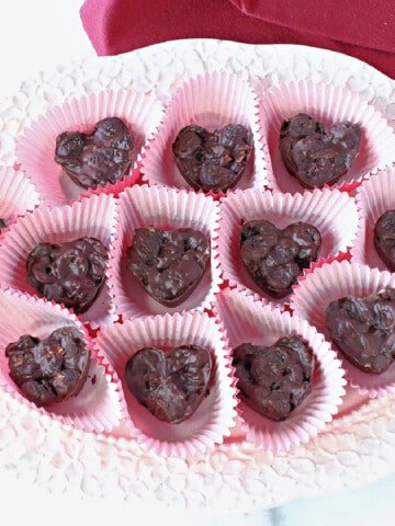 A pretty tray filled with Chocolate Covered Dried Cherry Clusters made into heart shapes.