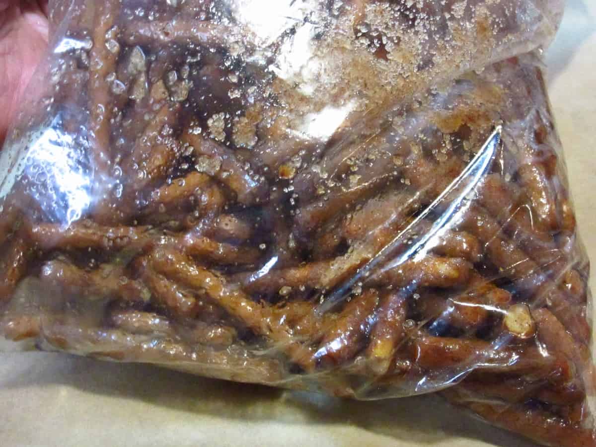 A bunch of pretzel sticks in a plastic bag coated with cinnamon and sugar.