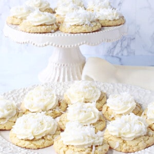 A pretty cake stand and plate filled with pretty Coconut Cake Cookies in white and ivory.