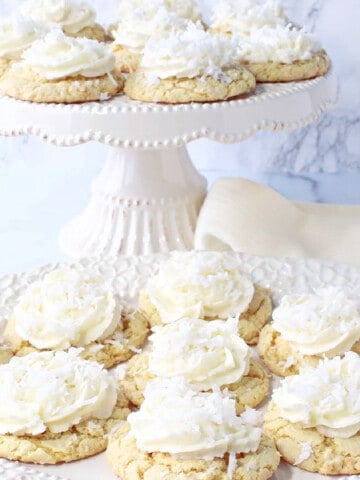 A pretty cake stand and plate filled with pretty Coconut Cake Cookies in white and ivory.