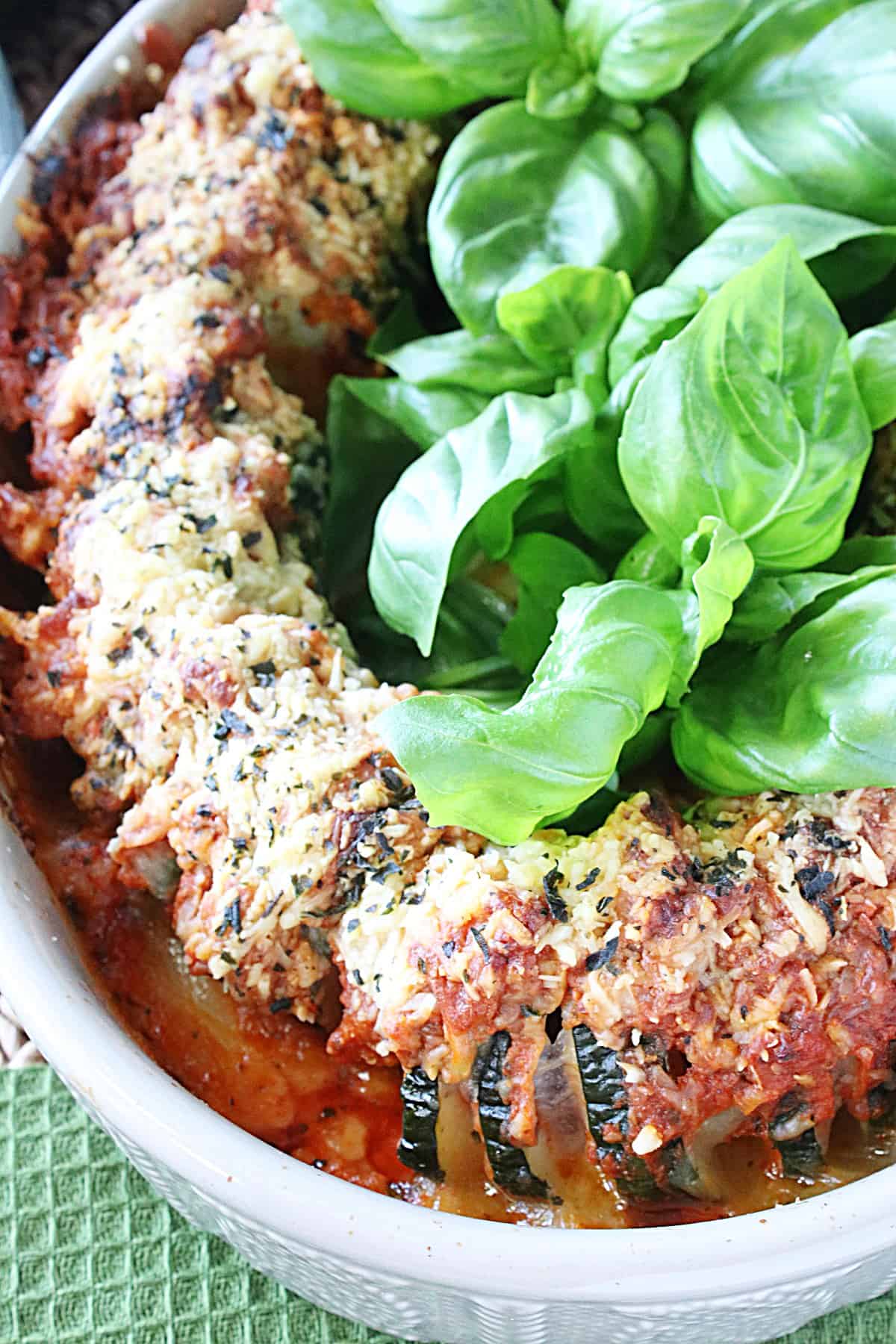 Sliced Pepperoni Pizza Hasselback Zucchini in a baking dish with melted cheese and fresh basil.