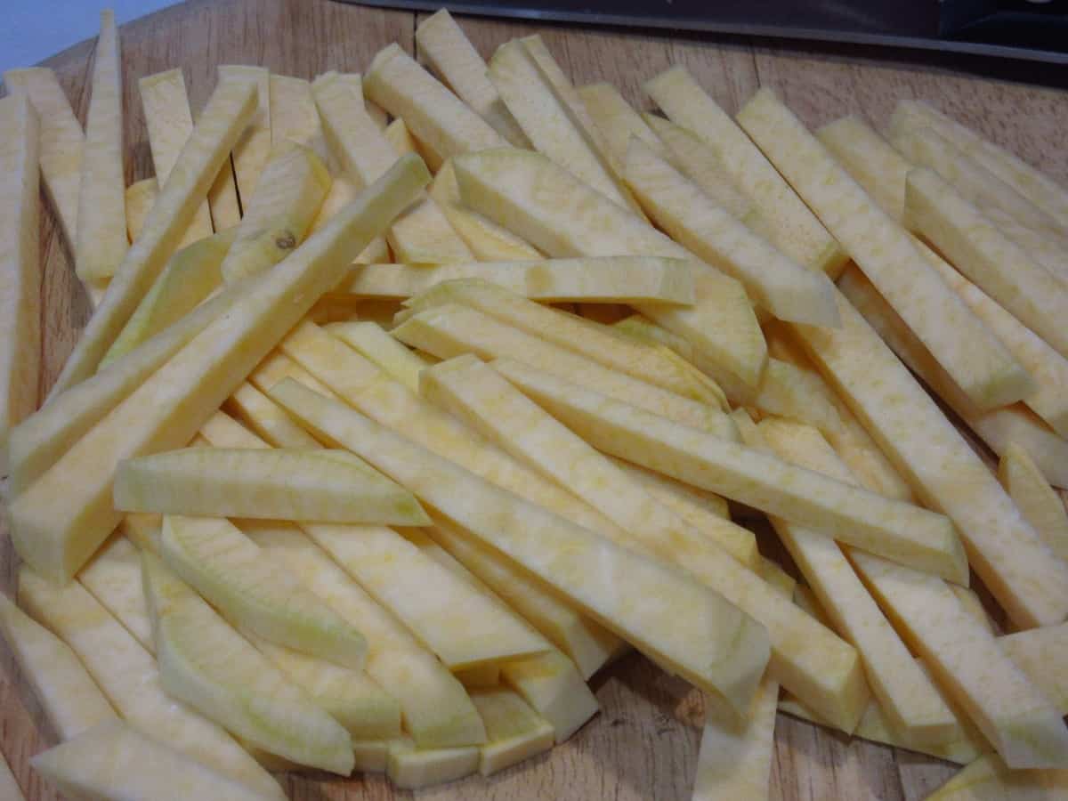 A pile of sliced Rutabaga Fries on a wooden cutting board.