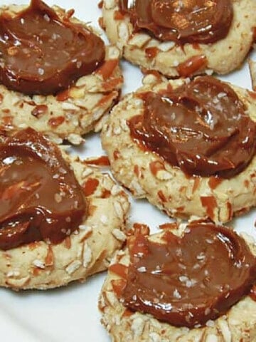 Closeup photo of several Caramel Pretzel Thumbprint Cookies on a plate.
