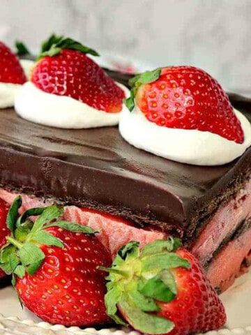 A layered Chocolate Strawberry Pudding Cake with fresh strawberries as garnish.