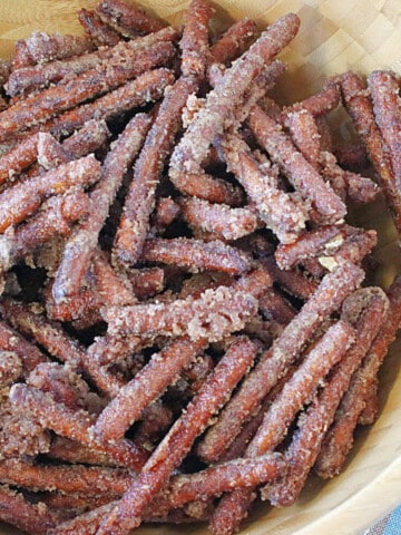 A bunch of pretzel sticks covered with cinnamon sugar in a wooden bowl.