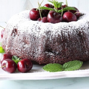 A pretty Chocolate Cherry Bundt Cake with fresh cherries and mint as garnish.
