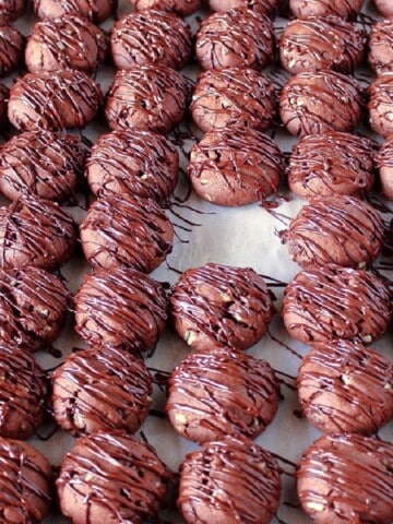 A whole tray with Double Chocolate Creme de Menthe Cookies with a chocolate drizzle and one cookie missing.