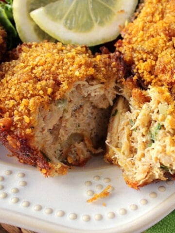 A closeup of the inside of a Muffin Tin Crab Cake with a cornflake coating on a pretty white plate.