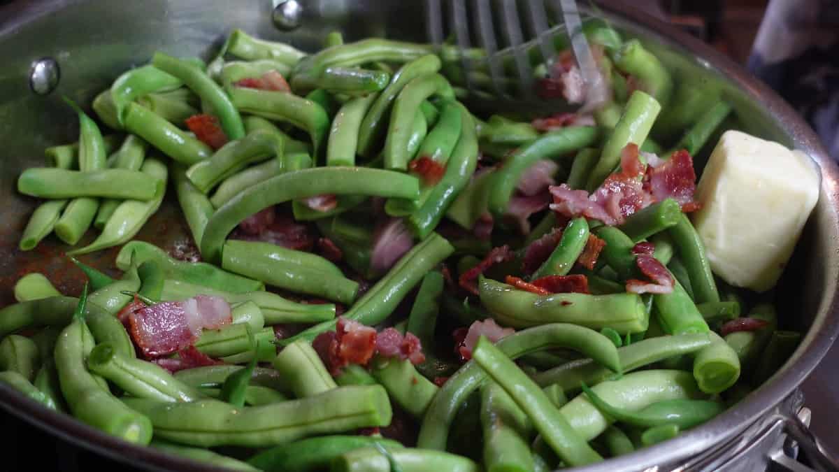 Bacon and green beans in a large skillet.