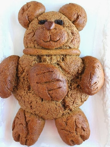 A cute brown bear made out of pumpernickel bread and he's holding a football.