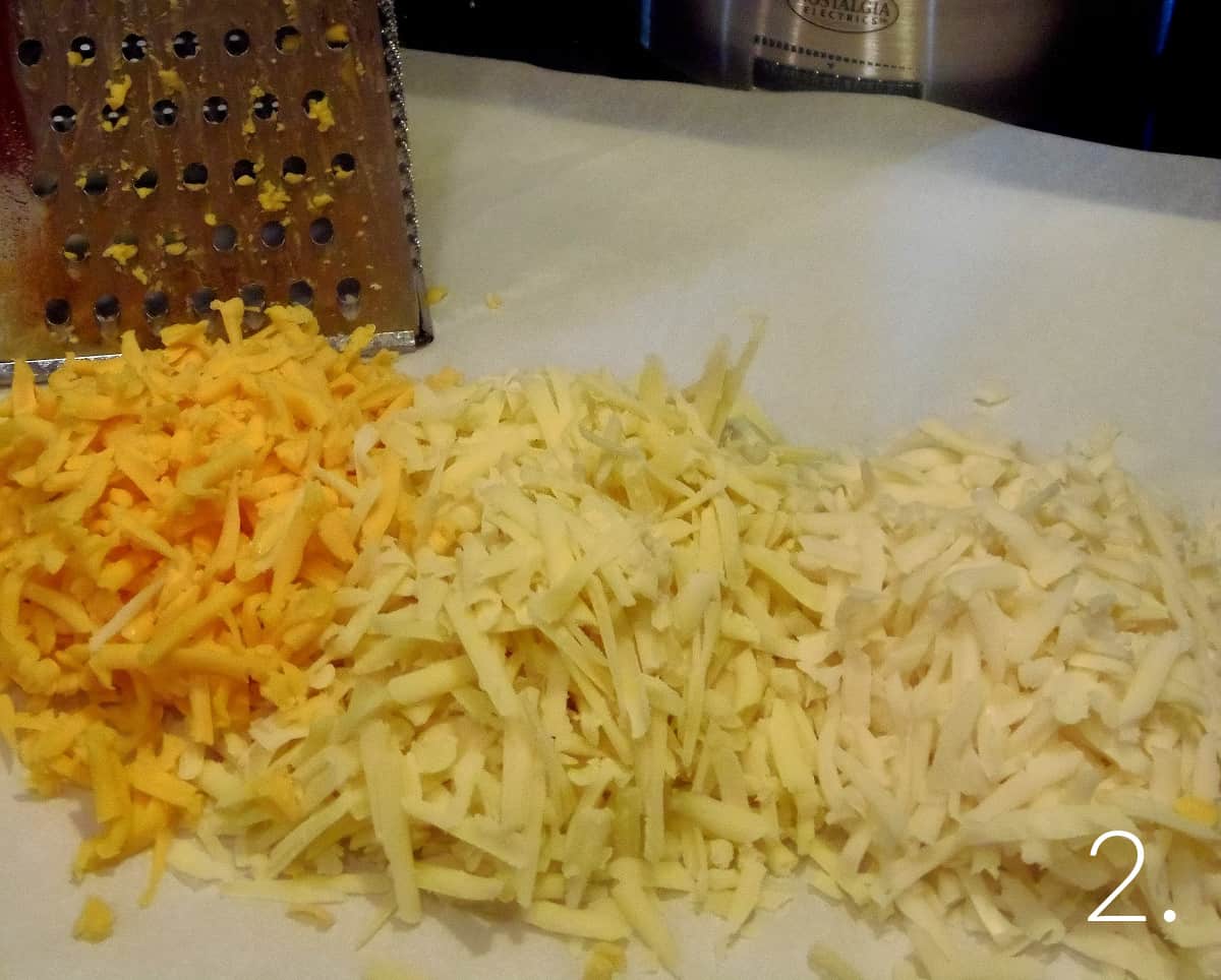 Three piles of shredded cheese for making fondue.
