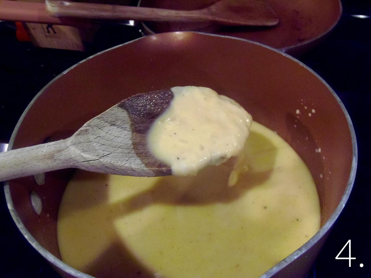 A wooden spoon in a pot of melted cheese.