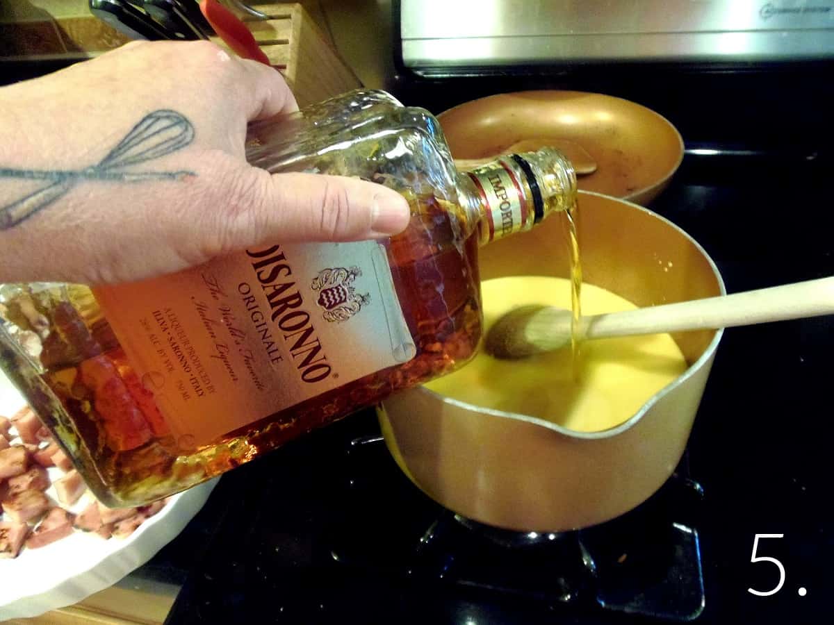 Amaretto liqueur being poured into a cheese sauce.