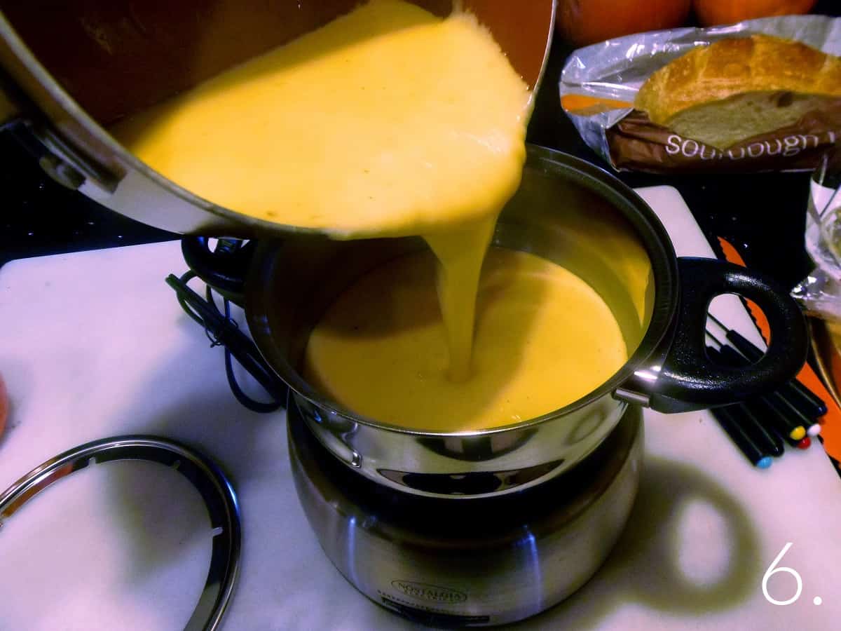 Gruyere cheese sauce being poured into a fondue pot.