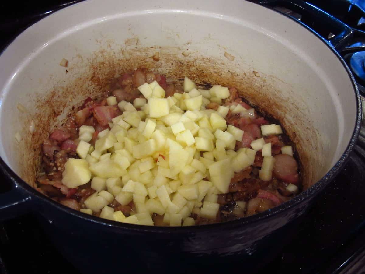 Diced apples added to a Dutch oven for making Apple Corn Chowder.